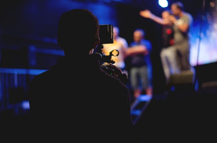 man-standing-on-stage-holding-microphone-1870438